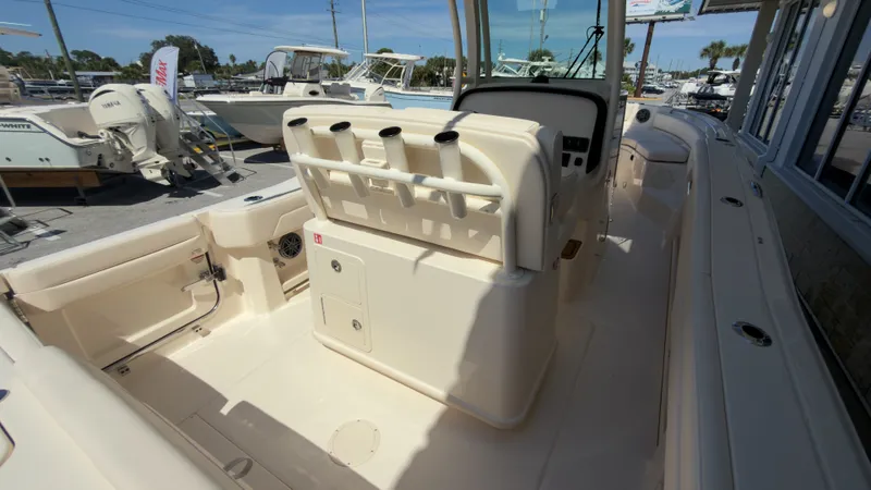 Slide: The Image of The image shows the cockpit of a Grady-White Canyon 266 boat. It features a light interior and multiple rod holders. - 34