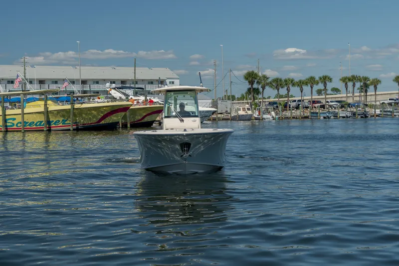 Slide: The Image of A 2027 Grady-White Canyon 266 boat navigates a calm waterway. - 6