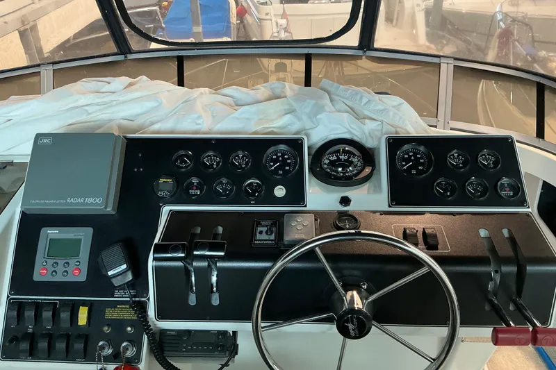 Slide: The Image of 1995 Carver 355 Aft Cabin Motor Yacht helm with gauges, steering wheel, and radar system. - 14