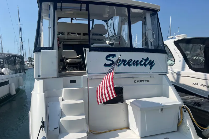 Slide: The Image of 1995 Carver 355 Aft Cabin Motor Yacht "Serenity" docked with American flag. - 24