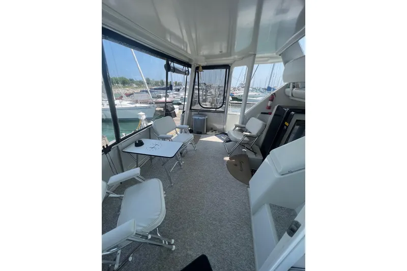 Slide: The Image of 1995 Carver 355 Aft Cabin Motor Yacht interior with seating and table, docked at marina. - 39