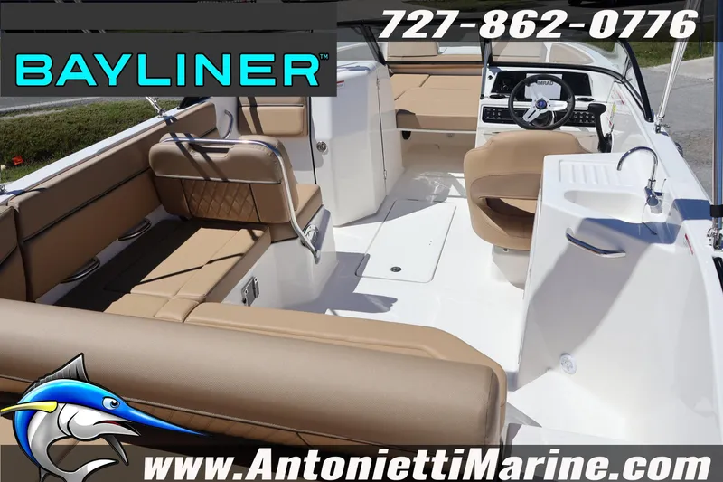 Slide: The Image of 2026 Bayliner D22 boat interior with tan seating, steering wheel, and sink. - 12