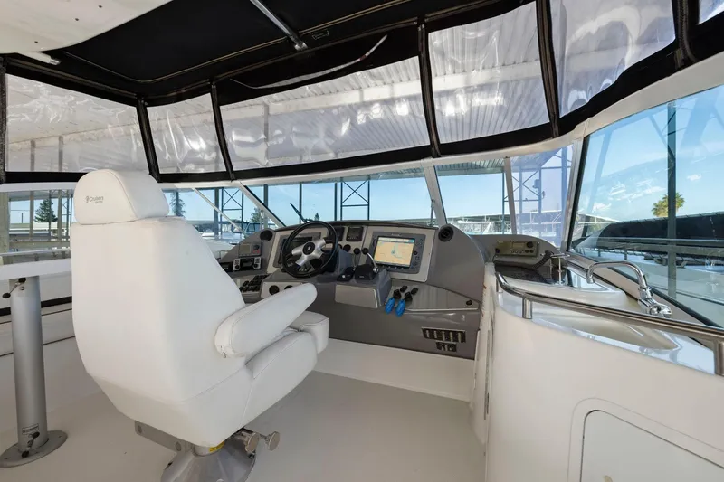 Slide: The Image of 2008 Cruisers Yachts 447 Sport Sedan helm with modern navigation equipment and white captain's chair. - 26