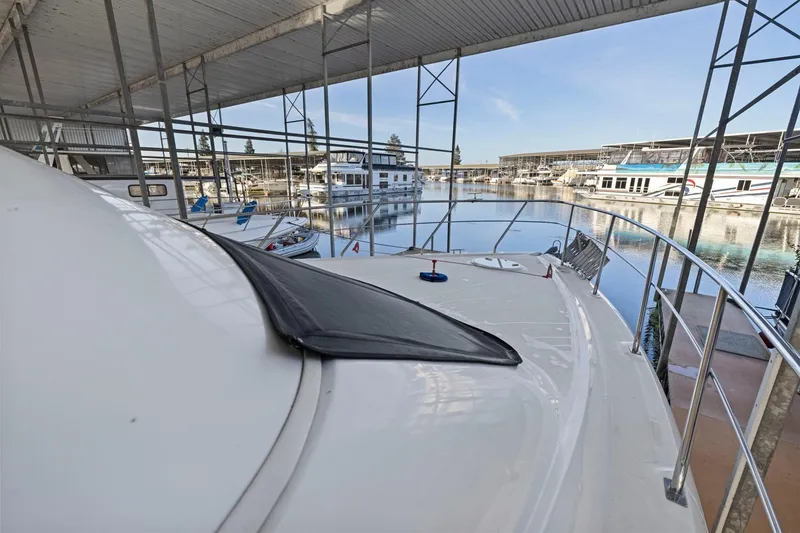 Slide: The Image of 2008 Cruisers Yachts 447 Sport Sedan docked in a marina under a covered structure. - 41