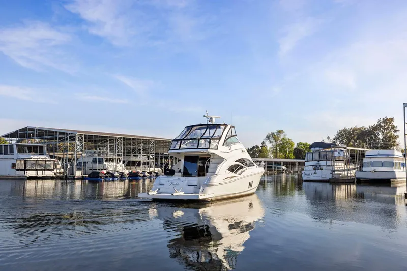 Slide: The Image of 2008 Cruisers Yachts 447 Sport Sedan docked at a marina under a clear blue sky. - 54