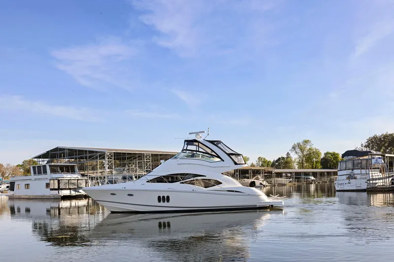 Slide: The Image of 2008 Cruisers Yachts 447 Sport Sedan on calm water near marina. - 63