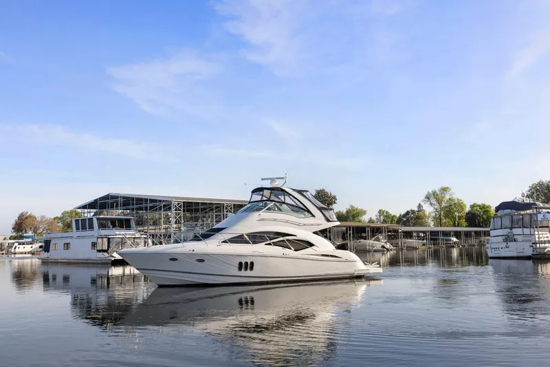 Slide: The Image of 2008 Cruisers Yachts 447 Sport Sedan docked at marina under clear blue sky. - 64