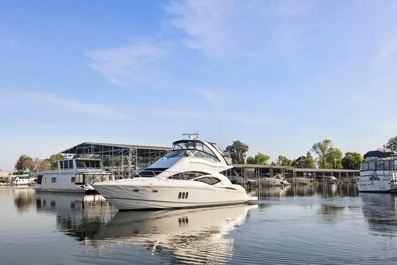 Slide: The Image of 2008 Cruisers Yachts 447 Sport Sedan on calm water near marina. - 65