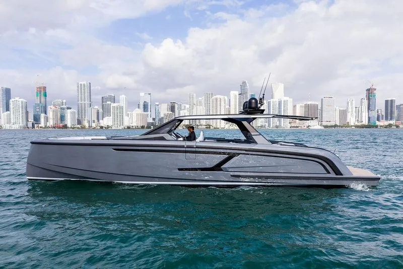 The Image of 2024 Vanquish Yachts VQ55 cruising near a city skyline on a sunny day. - 0