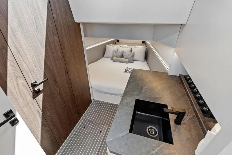 Slide: The Image of Luxurious interior of 2024 Vanquish Yachts VQ55, featuring a cozy bed and modern sink area. - 18
