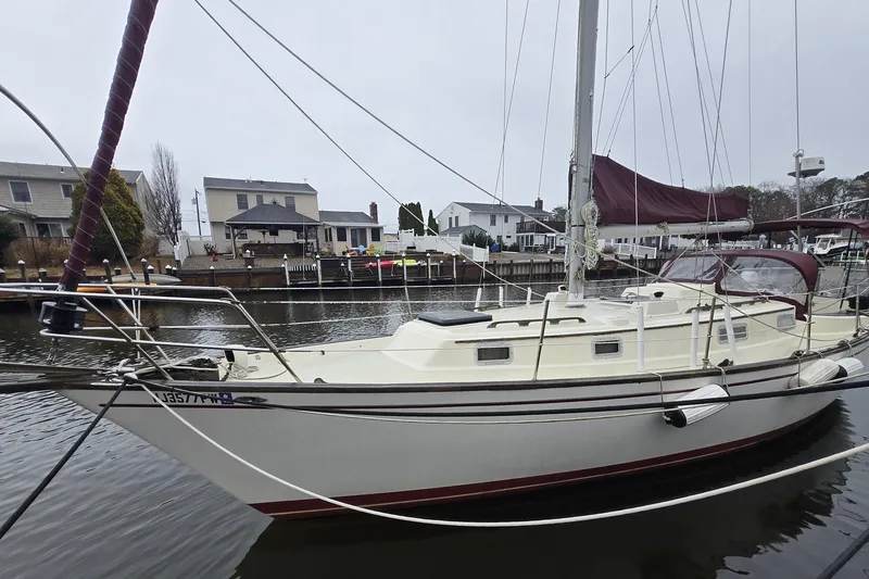 Slide: The Image of 1980 Pearson 365 Sloop docked in a residential marina setting. - 10