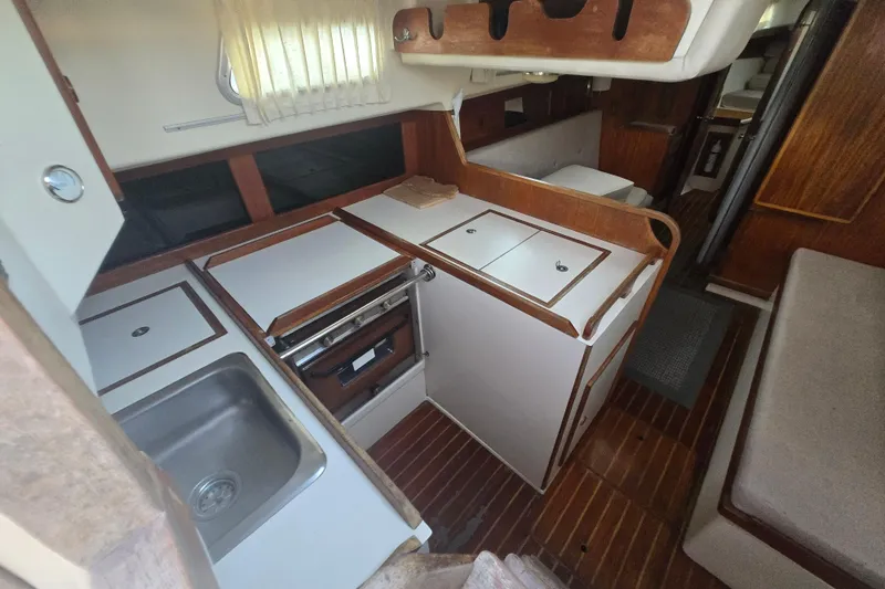 Slide: The Image of Interior of 1980 Pearson 365 Sloop sailboat with compact kitchen and wooden accents. - 38