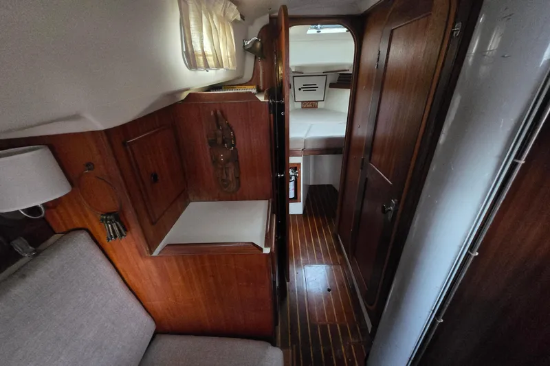 Slide: The Image of Interior of 1980 Pearson 365 Sloop, featuring wooden cabinetry and cozy sleeping quarters. - 46