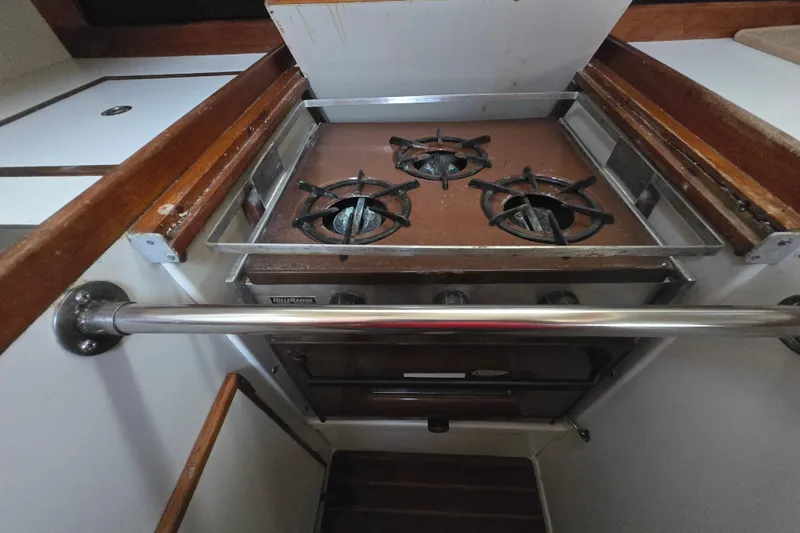 Slide: The Image of Vintage 1980 Pearson 365 Sloop galley with a three-burner stove and wooden cabinetry. - 54