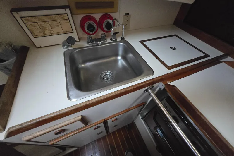 Slide: The Image of Compact kitchen area in a 1980 Pearson 365 Sloop sailboat, featuring a stainless steel sink. - 56