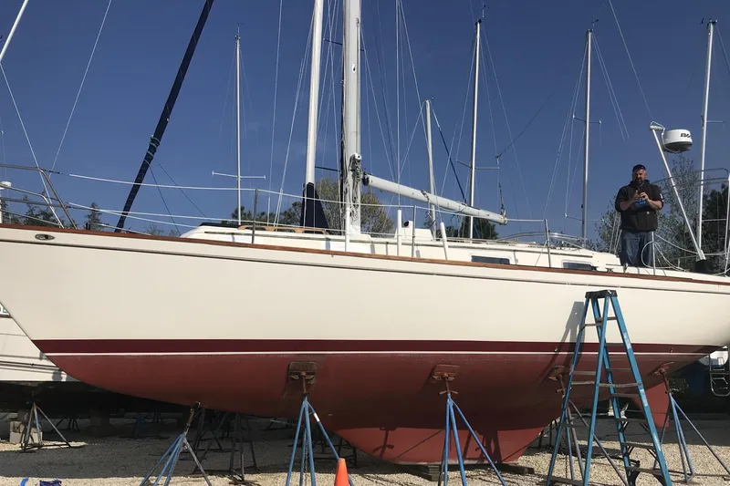 Slide: The Image of 1980 Pearson 365 Sloop sailboat on stands, with a person inspecting it. - 24