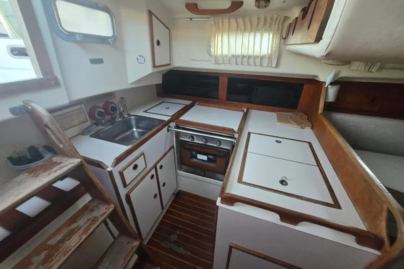 Slide: The Image of Interior of 1980 Pearson 365 Sloop sailboat, featuring compact kitchen with stove and sink. - 39