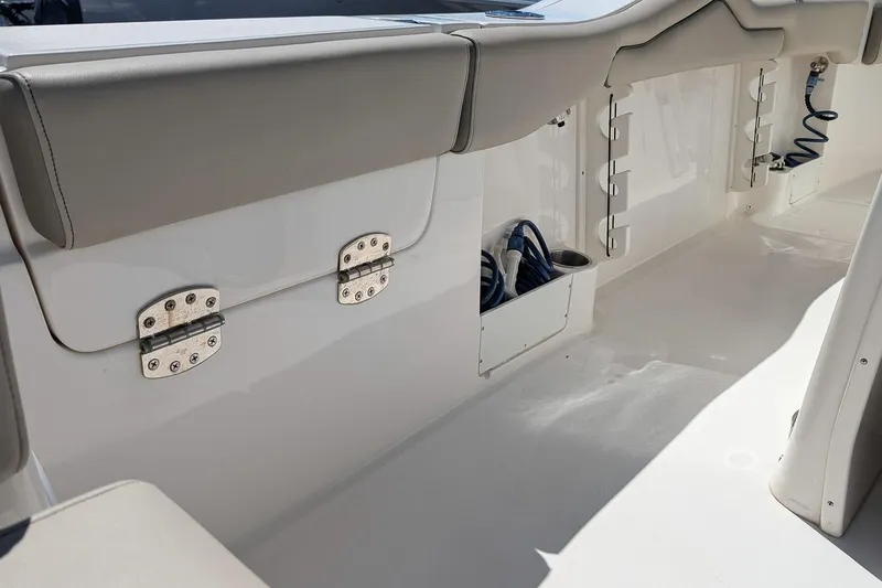 Slide: The Image of 2023 Key West 263 FS boat interior with storage compartments and cushioned seating. - 10