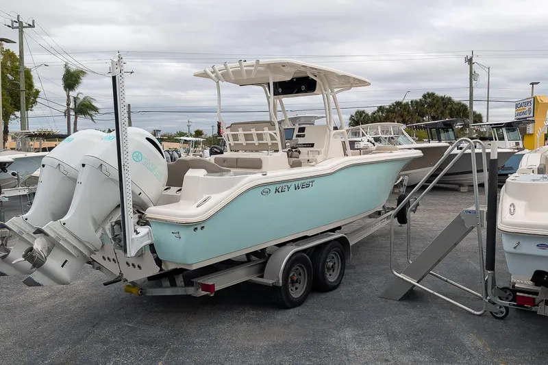 Slide: The Image of 2023 Key West 263 FS boat on trailer, featuring dual outboard engines. - 2