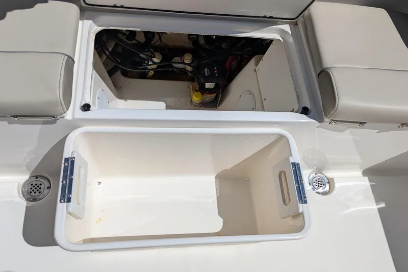 Slide: The Image of 2023 Key West 263 FS boat storage compartment with open hatch and seating. - 9