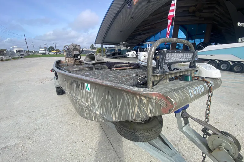 Slide: The Image of 2009 Gator Trax MUD BUDDY 17 X 50 boat on trailer, camo design, outdoor setting. - 10
