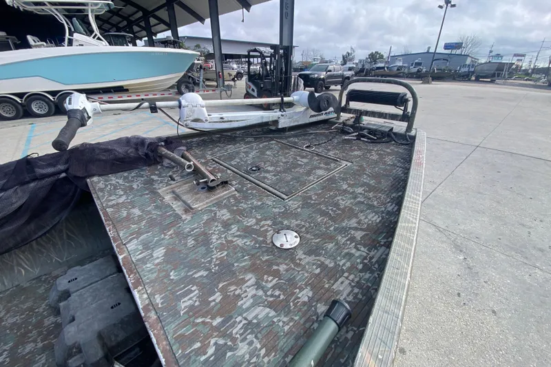 Slide: The Image of 2009 Gator Trax MUD BUDDY boat with camo deck, parked outdoors. - 11