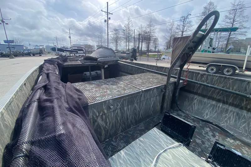 Slide: The Image of 2009 Gator Trax MUD BUDDY 17 X 50 boat with camouflage interior, parked outdoors. - 15