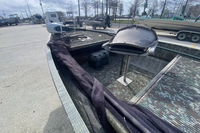 Slide: The Image of 2009 Gator Trax MUD BUDDY boat with camo interior, parked outdoors. - 18