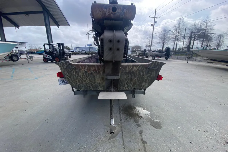 Slide: The Image of 2009 Gator Trax MUD BUDDY 17 X 50 boat with camo design, parked outdoors. - 5