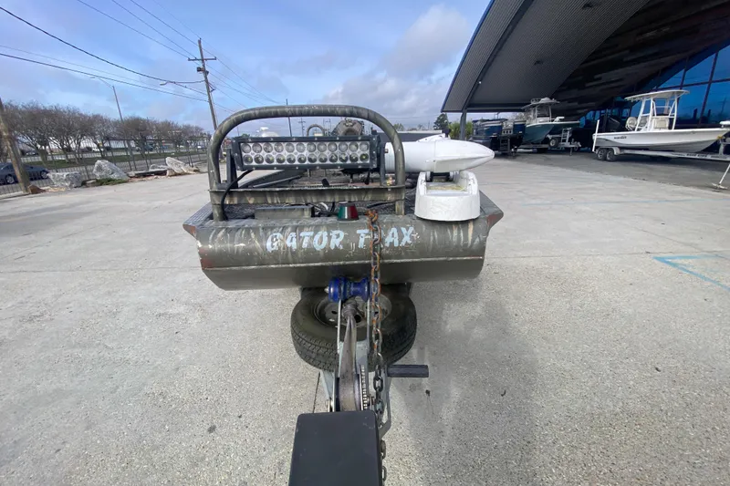 Slide: The Image of 2009 Gator Trax MUD BUDDY 17 X 50 boat on trailer, outdoor dealership setting. - 9