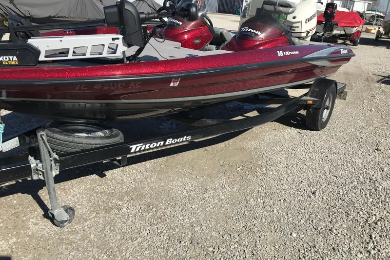 The Image of 2008 Triton 18 Explorer boat on trailer, parked on gravel surface. - 2