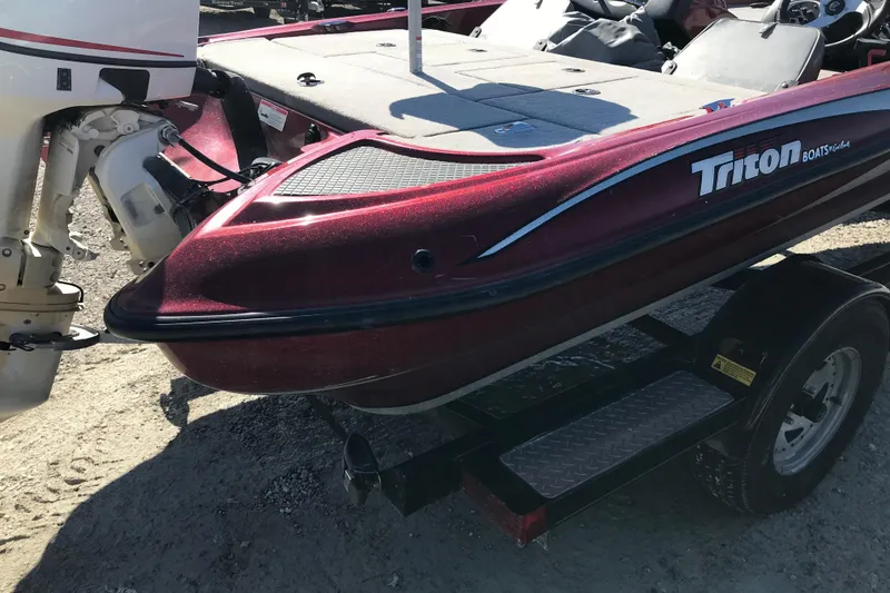 Slide: The Image of 2008 Triton 18 Explorer boat on trailer, featuring maroon finish and outboard motor. - 4