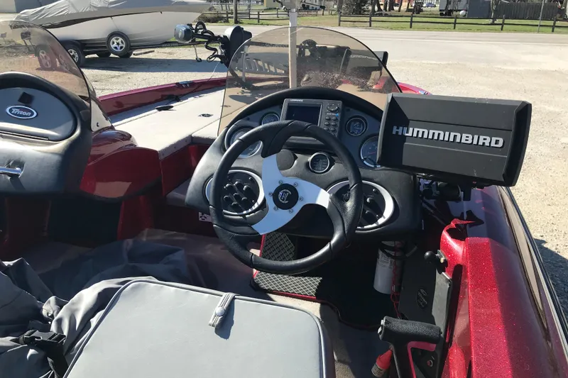 Slide: The Image of 2008 Triton 18 Explorer boat dashboard with steering wheel and Humminbird fish finder. - 6