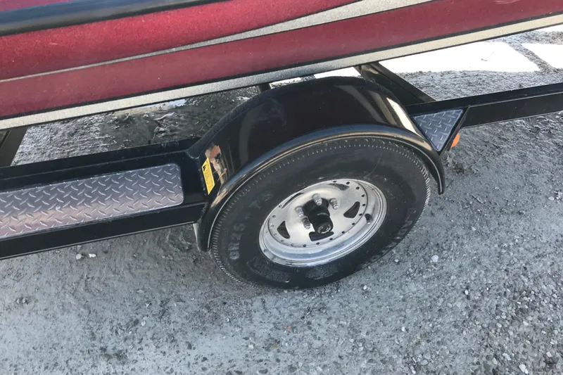 Slide: The Image of Trailer wheel of a 2008 Triton 18 Explorer boat on gravel surface. - 7