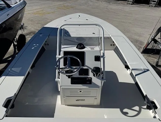 Slide: The Image of 2026 Hewes Redfisher 21 boat with steering console, parked outdoors. - 16