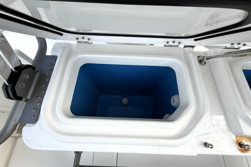 Slide: The Image of Open storage compartment on 2023 Solace 30 HCS boat, featuring a blue interior. - 19
