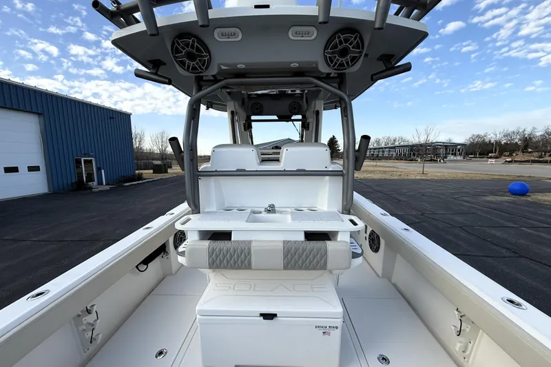 Slide: The Image of 2023 Solace 30 HCS boat interior with seating and storage, under a clear blue sky. - 22