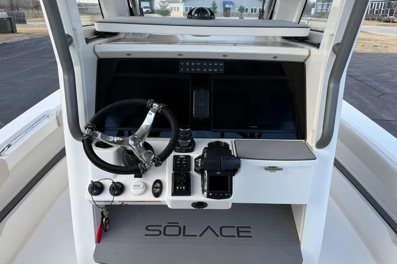 Slide: The Image of 2023 Solace 30 HCS boat dashboard with steering wheel and control panel. - 23