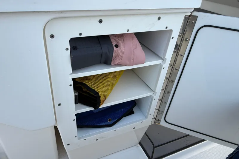 Slide: The Image of Storage compartment on 2023 Solace 30 HCS boat with organized shelves and gear. - 30
