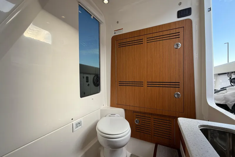 Slide: The Image of 2023 Solace 30 HCS boat interior with wooden cabinetry and modern toilet. - 37