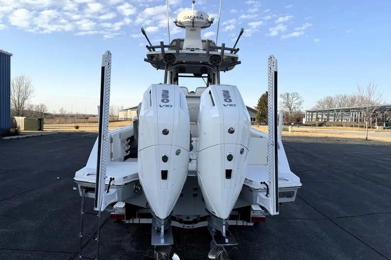 Slide: The Image of 2023 Solace 30 HCS boat with dual outboard engines, parked outdoors under a clear sky. - 45