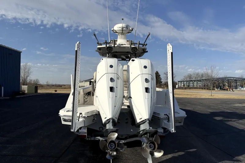 Slide: The Image of 2023 Solace 30 HCS boat with dual outboard engines, parked outdoors under a clear sky. - 5