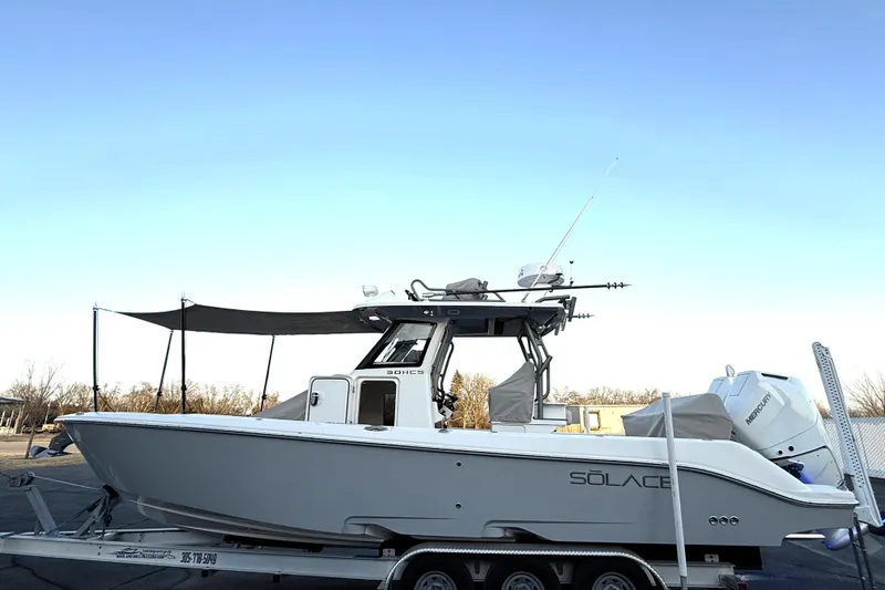 Slide: The Image of 2023 Solace 30 HCS boat on trailer, side view under clear blue sky. - 57