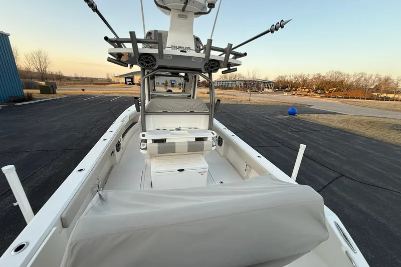 Slide: The Image of 2023 Solace 30 HCS boat with fishing rods, parked on asphalt near grassy area. - 58
