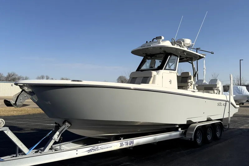 Slide: The Image of 2023 Solace 30 HCS boat on trailer, parked outdoors under clear sky. - 6