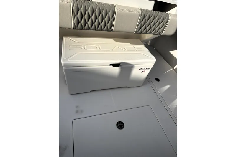 Slide: The Image of 2023 Solace 30 HCS boat interior with cushioned seating and storage compartment. - 9