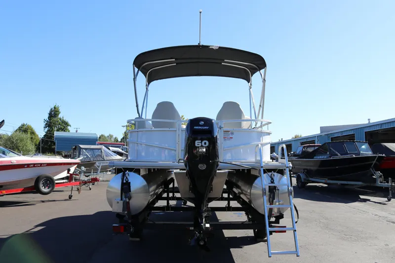 Slide: The Image of 2023 SunChaser Vista 20 Fish pontoon boat with Mercury 60 engine, parked outdoors. - 2