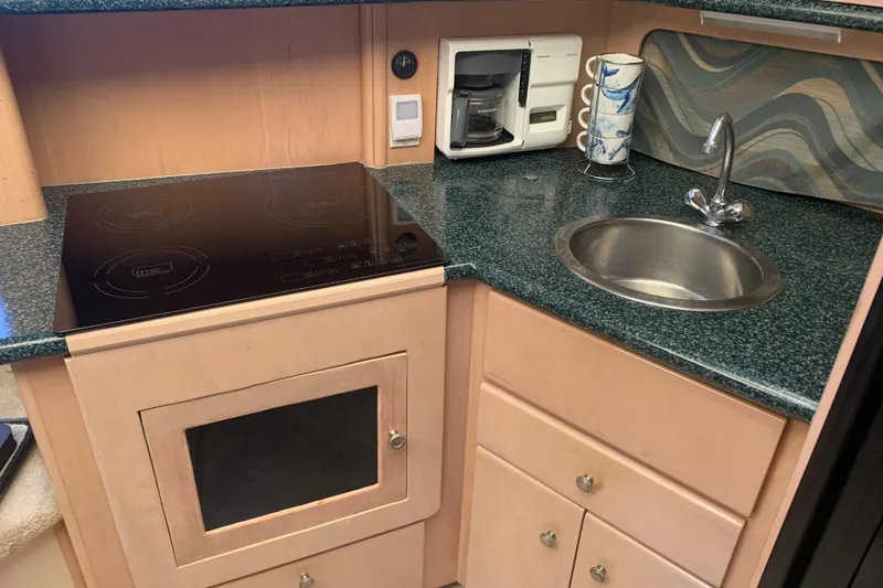Slide: The Image of Compact yacht kitchen with stove, sink, and coffee maker in Carver 356 Aft Cabin Motor Yacht. - 18