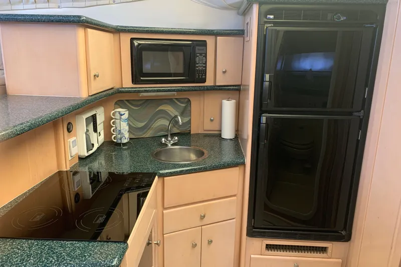 Slide: The Image of Compact kitchen in 2000 Carver 356 Aft Cabin Motor Yacht with microwave, stove, and fridge. - 19