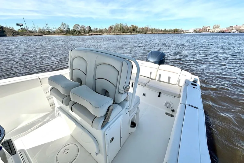 Slide: The Image of 2021 Sea Hunt Ultra 255 SE boat on calm river waters, featuring comfortable seating. - 10
